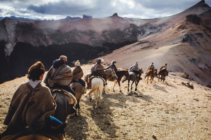 Group of riders following the edge of a mountain in Tierra del Fuego, Patagonia